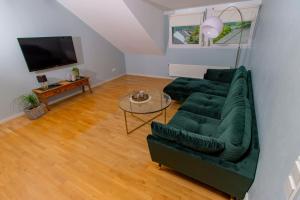 ein Wohnzimmer mit einem grünen Sofa und einem Tisch in der Unterkunft Weingut Gerd Müllers in Kröv