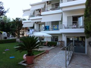 a white building with a potted plant in front of it at Asfodelos Apartment Hotel in Kakovatos