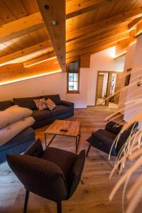 a living room with couches and a wooden ceiling at Leni´s Appartements in Fieberbrunn