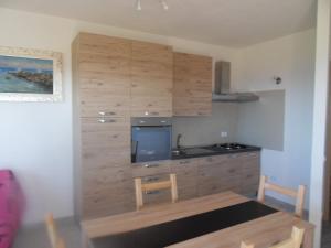 una cucina con armadi in legno e un tavolo in una stanza di bella vista a Castelsardo