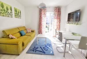 a living room with a yellow couch and a table at Apartments Villa Vera in Tivat
