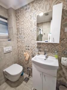 a bathroom with a white sink and a toilet at Apartments Villa Vera in Tivat