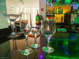cuatro copas de vino sentadas en la parte superior de un bar en Presken Hotel @Oniru en Lagos