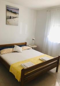 een slaapkamer met een groot bed en een gele deken bij Vir Holidays in Vir