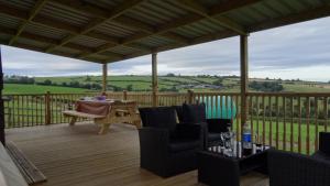 a patio with chairs and a table on a deck at Woodbatch Camping & Glamping in Bishops Castle