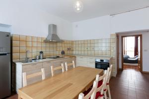 cocina con mesa de madera con sillas y fregadero en Maison Isabella - Appartamento nel cuore di Aosta, en Aosta