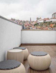 balcón con 2 taburetes y vistas a la ciudad en 296 Heritage Apartments, en Vila Nova de Gaia