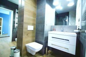 a bathroom with a white toilet and a sink at Dream LUX Apartments in Krakow