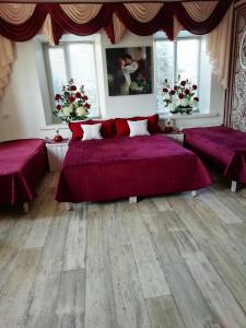 ヘルソンにあるGuest House Comfortのベッドルーム1室(紫のシーツとウッドフロアのベッド2台付)