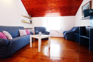 ein Wohnzimmer mit einem blauen Sofa und einem Tisch in der Unterkunft Apartment Dulcis in Stari Grad