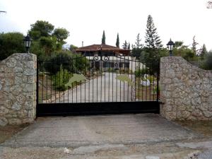 a black gate with a driveway and a building at Villa Rita - Porto Heli in Porto Heli
