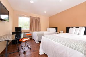 a hotel room with two beds and a desk at Valued Stay Madison in Madison