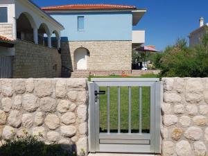 un portail dans une clôture en pierre devant une maison dans l'établissement Holiday home Ankica, à Ražanac