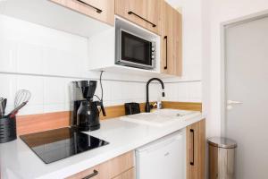 a kitchen with a sink and a microwave at Le Temple de La Rochelle in La Rochelle