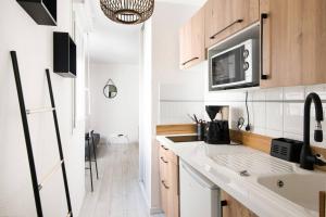 a kitchen with a sink and a microwave at Le Temple de La Rochelle in La Rochelle