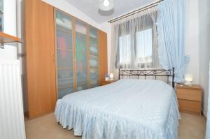 a bedroom with a white bed and a window at Elios Villa Chalkidiki in Skala Fourkas