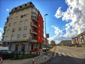 a tall red building on a city street at Apartment For a Day in Podgorica