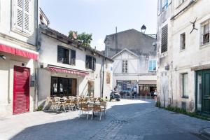 une rue avec des chaises et des tables dans une ruelle dans l'établissement Le Temple de La Rochelle, à La Rochelle