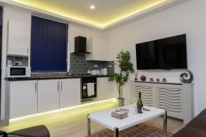 cocina con armarios blancos y mesa blanca en TOWLER HOUSE APARTMENTS 6 beds in 3 bedrooms en Leeds