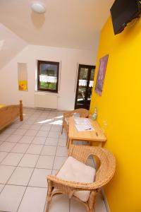 a room with a table and chairs and a yellow wall at Weingut Christian Bucher in Burg an der Mosel