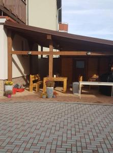 a covered patio with a picnic table and benches at Penzion Alka in Kaplice