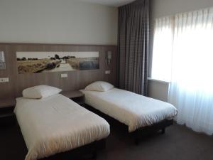 En eller flere senge i et værelse på Hotel Ekamper