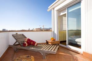 a bench on a balcony with a view of a bedroom at Gaudi Views Apartment in Barcelona