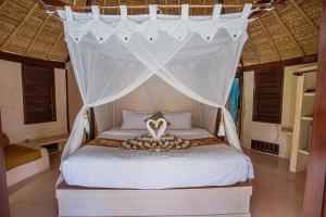 
a bed with a canopy on top of it at Sanghyang Bay Villas in Nusa Lembongan
