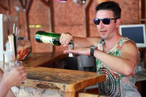 a man is pouring a bottle of beer at Family hotel Tropicana in Ravda