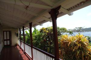 a porch of a house with a view of the water at Finjam Cottage in Port Antonio