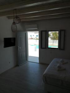 a bedroom with a bed and a door to a pool at Ftelia Breeze in Klouvas
