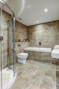 a bathroom with a tub and a toilet and a sink at The Old Mill Inn in Pitlochry