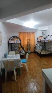 Pokój z 2 łóżkami, stołem i krzesłami w obiekcie EKONUMI ROOMS at Moonwalk Paranaque w mieście Manila