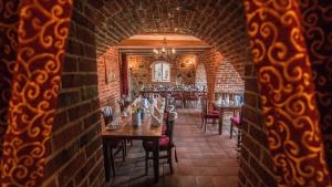 un comedor con mesas y sillas y una pared de ladrillo en Schloss Zehdenick en Zehdenick