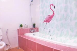 a pink flamingo standing on a bath tub in a bathroom at Makkasan Happy Home in Bangkok +15 photos