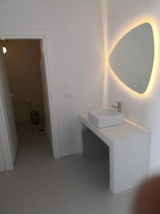 a white bathroom with a sink and a mirror at Ftelia Breeze in Klouvas