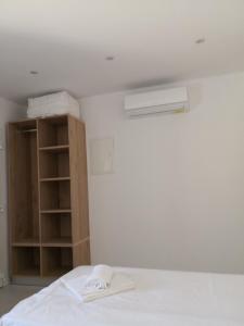 a bedroom with a white bed and a book shelf at Ftelia Breeze in Klouvas