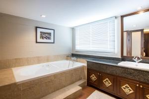 a large bathroom with a tub and two sinks at Viangbua Mansion in Chiang Mai