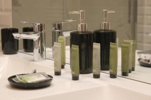 a group of bottles of soap on a bathroom sink at Les Bois de Champagne L'industriel in Magnant