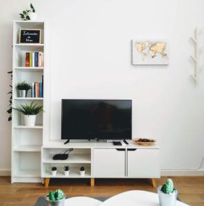 un centro de entretenimiento blanco con TV de pantalla plana en la sala de estar en Los Patios de la Caleta, en Cádiz