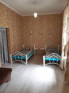 a room with two beds and two tables in it at Sofija apartamenti in Daugavpils