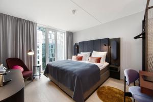 a bedroom with a large bed and a large window at Clarion Hotel Oslo in Oslo