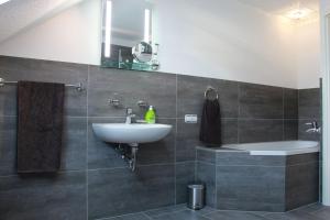 een badkamer met een wastafel, een toilet en een spiegel bij Aparts Oberhausen in Oberhausen