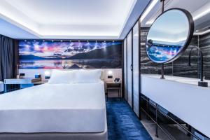 a hotel room with a bed and a mirror at OASIS AVENUE - A GDH HOTEL in Hong Kong