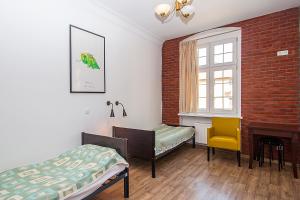 a bedroom with a bed and a chair and a fireplace at Hostel Wratislavia in Wrocław