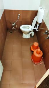 a bathroom with a toilet and a bucket on the floor at Hotel Laxmi Palace in Shirdi