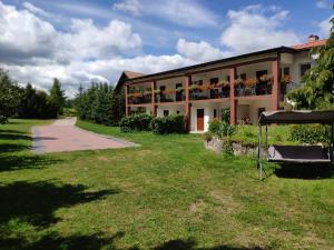 a building with balconies and a grass yard at Apartamenty wakacyjne nad jeziorem Juksty in Mrągowo