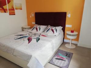 a bedroom with a bed with white sheets and colorful pillows at Buddha house in Torrox Costa +46 photos