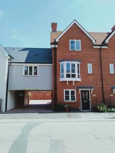 a red brick house with a garage on a street at Prestbury Bed & Breakfast in Salisbury