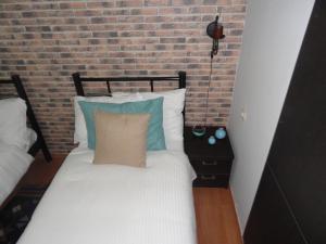 a bedroom with a bed with a brick wall at Apartment Fine Home in Tbilisi City